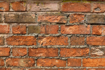 Brick wall with crumbling mortar in need of repair